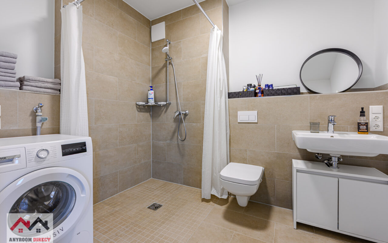 Spacious bathroom with a shower and washing machine