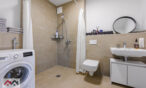 Spacious bathroom with a shower and washing machine
